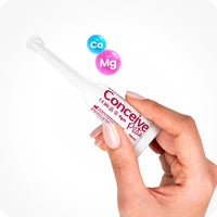 For Conceive Plus Fertility Lubricant Combo 75ml + 8 applicators (DE), image showing a single 4g pre-filled fertility lubricant applicator held between two fingers, with floating Ca and Mg ion graphics to emphasize fertility-supporting minerals, presented on white background for a clinical, professional look.